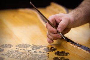 Expert Piano Rebuilding & Piano Restoration - Painting Soundboard Bridges.